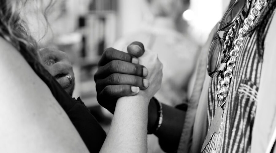 grayscale photo of man and woman holding their hands