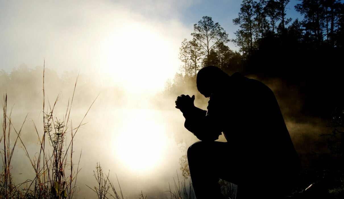 silhouette of kneeling man