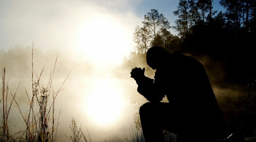 silhouette of kneeling man