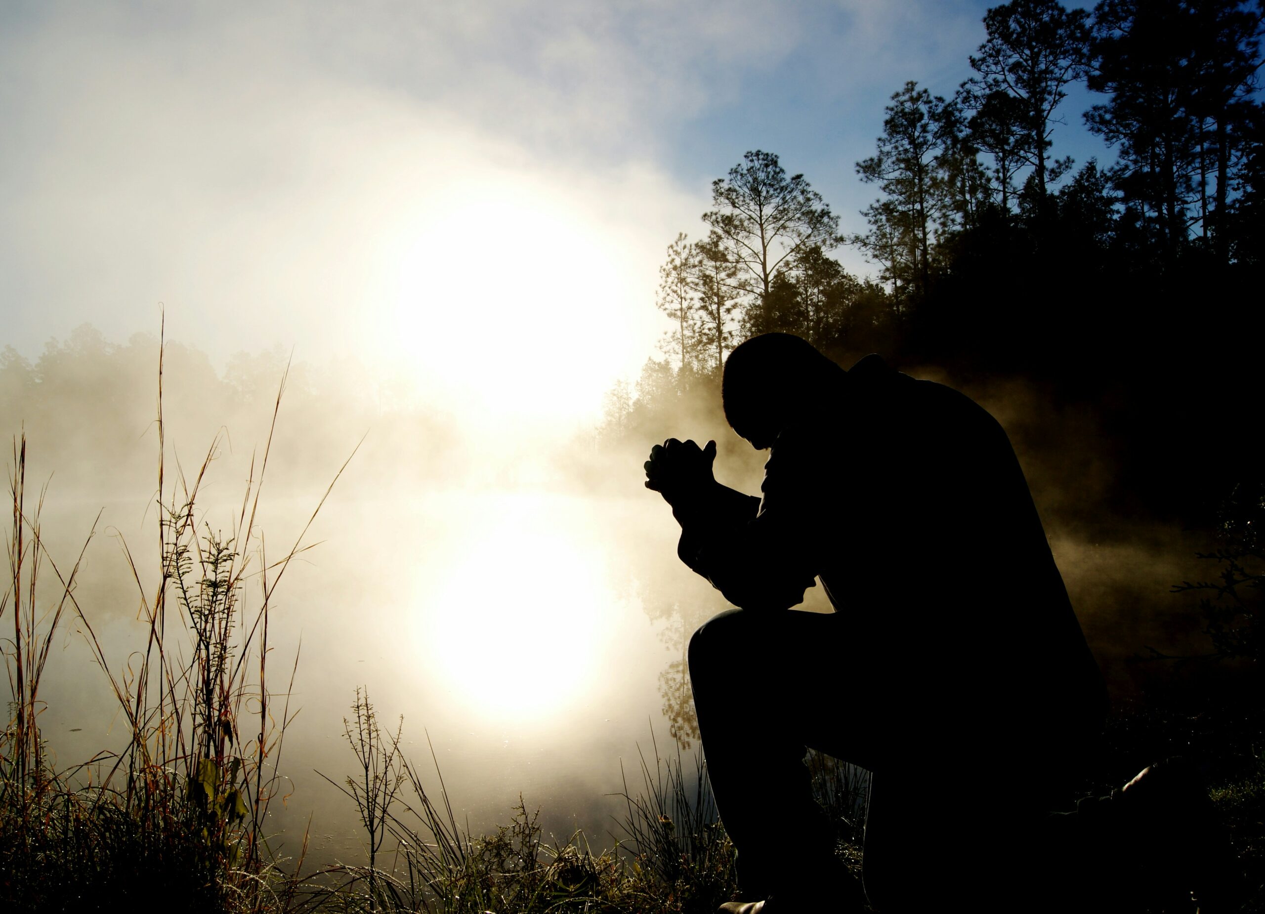 silhouette of kneeling man