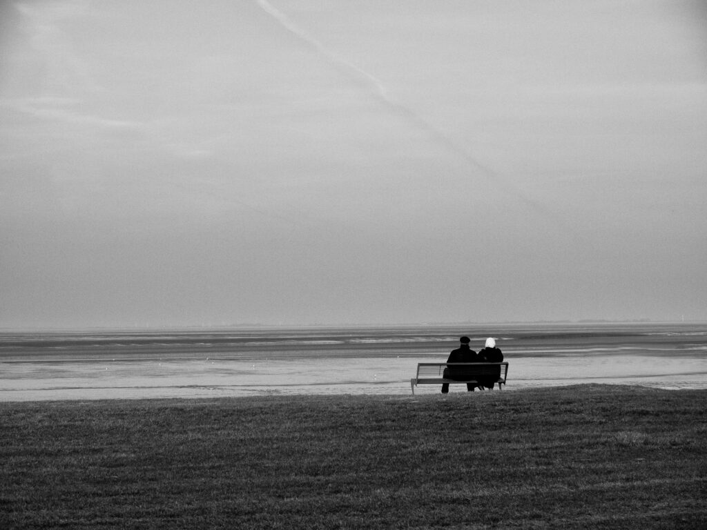 silhouette of two person sitting on bench