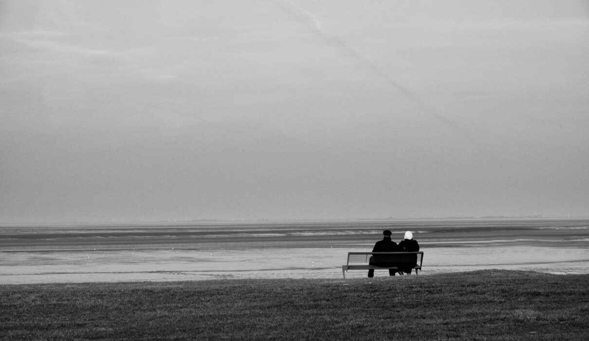 silhouette of two person sitting on bench