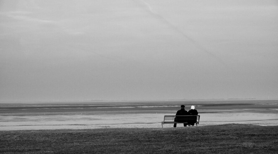 silhouette of two person sitting on bench