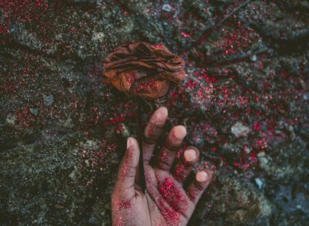 person's left hand covered with red glitters