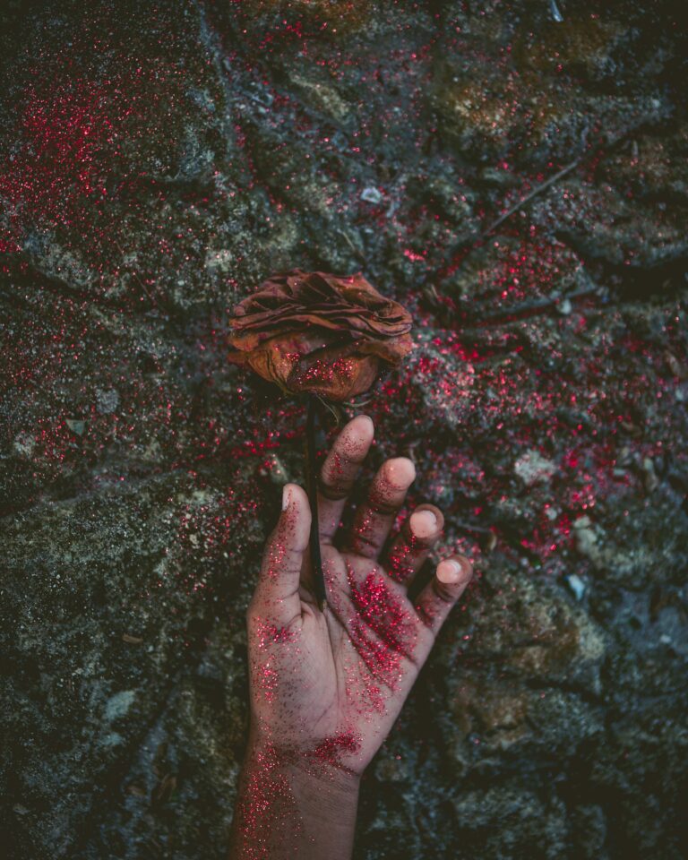 person's left hand covered with red glitters