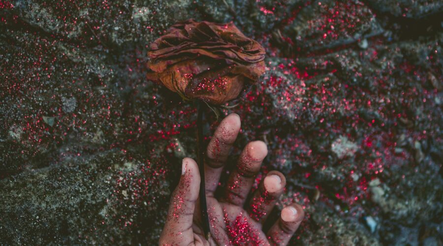 person's left hand covered with red glitters