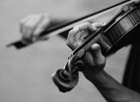 grayscale photo of person playing violin