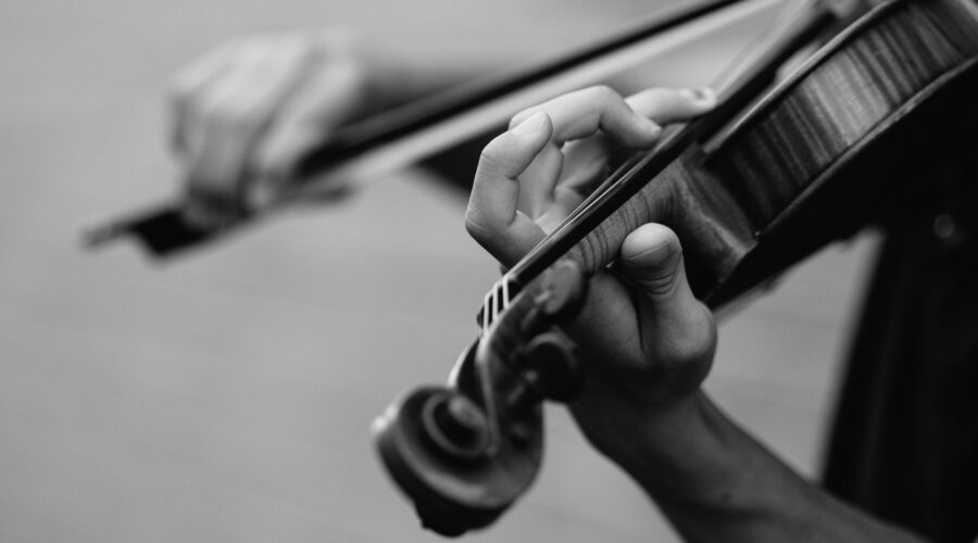 grayscale photo of person playing violin