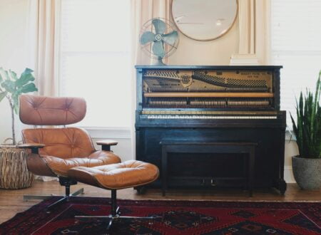 black upright piano near brown leather padded chair