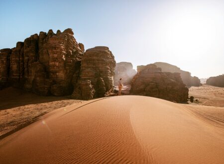 a person standing on top of a sand dune