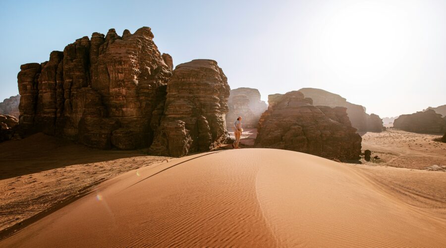 a person standing on top of a sand dune