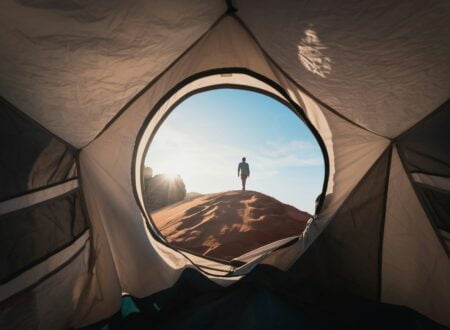 a man standing in a tent looking out into the distance