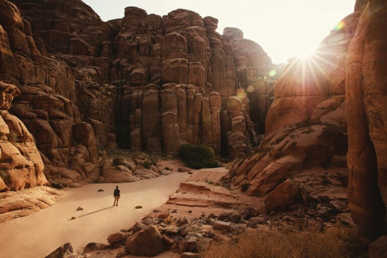 a person standing in a canyon surrounded by rocks