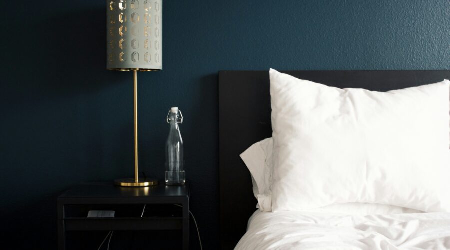 gray table lamp beside white bed pillow