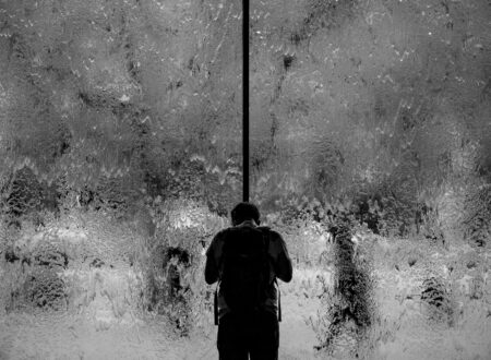 man standing on glass wall with pouring water